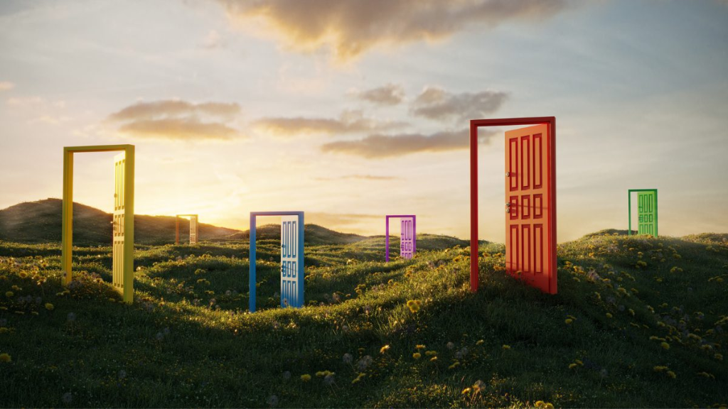 Open colourful doors standing across a green meadow under a sunset sky
